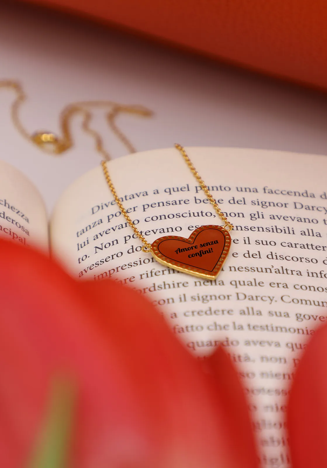 Cuore Intrecciato color oro con una frase incisa, appoggiato su un libro