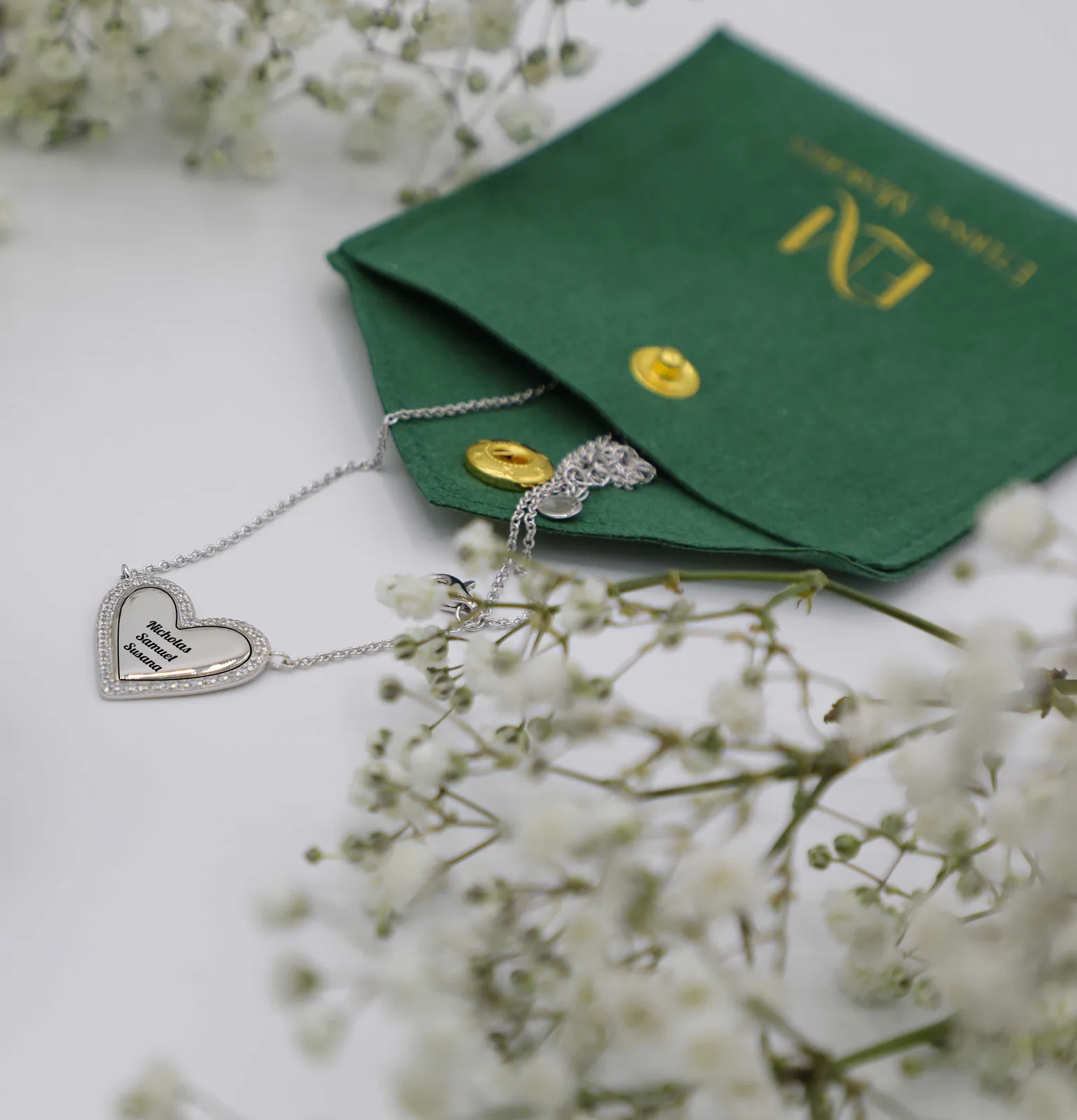 Collana Cuore Intrecciato in argento con nomi incisi, sulla pochette verde