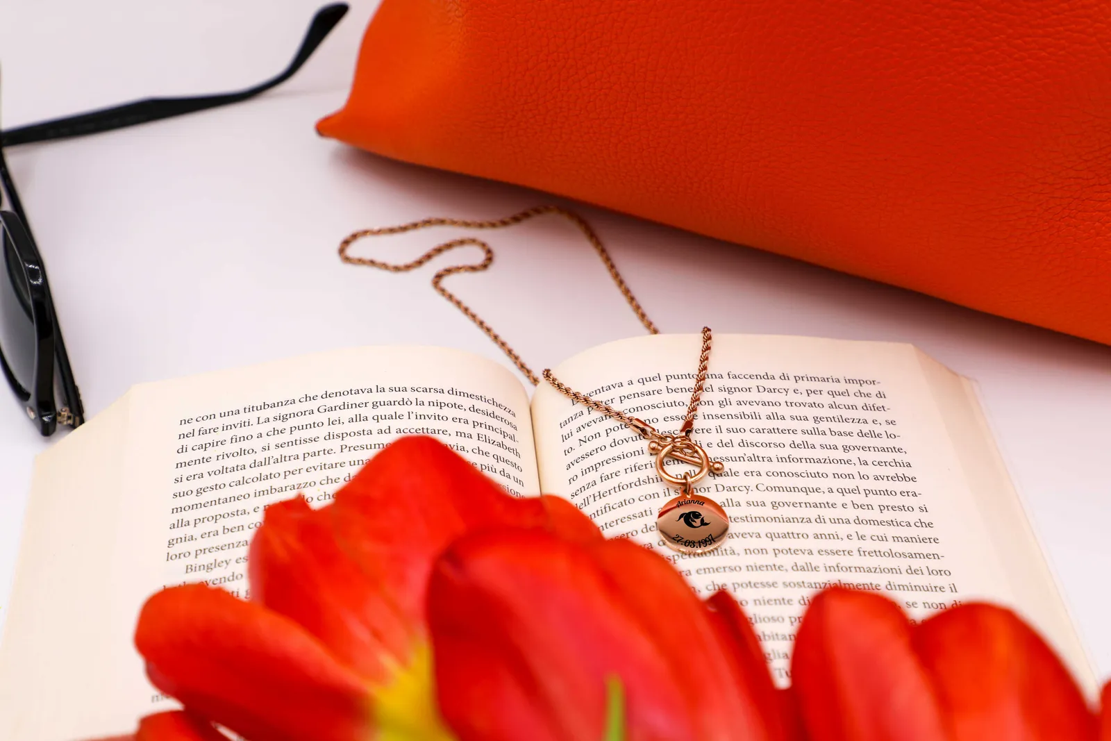 Collana Trama T color oro rosato su un libro aperto