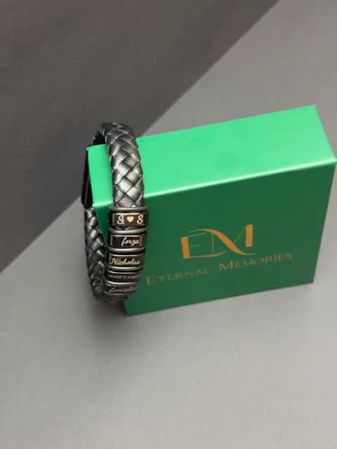 Bracciale in pelle intrecciata con placche incise appoggiato sulla scatola regalo verde