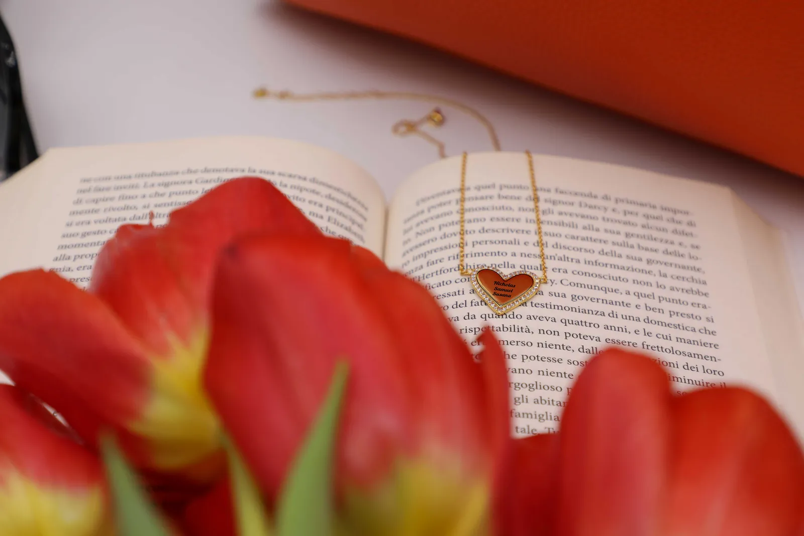 Collana a cuore Cuore Intrecciato su un libro aperto, tra tulipani rossi